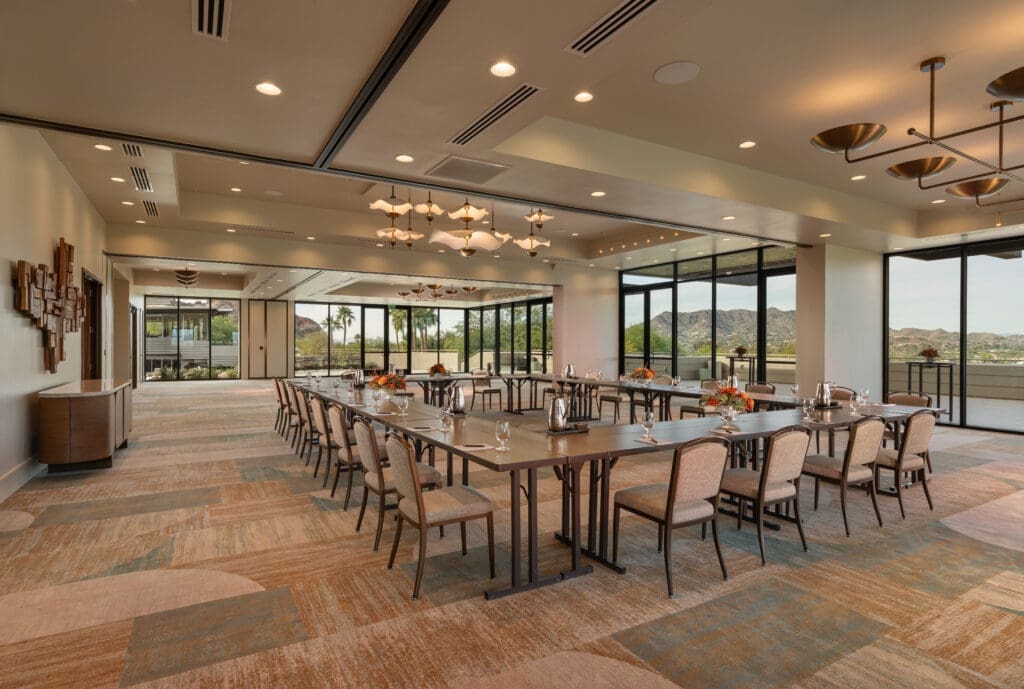 Views Ballroom at Sanctuary Camelback Mountain Resort & Spa set for a meeting with large windows overlooking the desert landscape and Camelback Mountain.