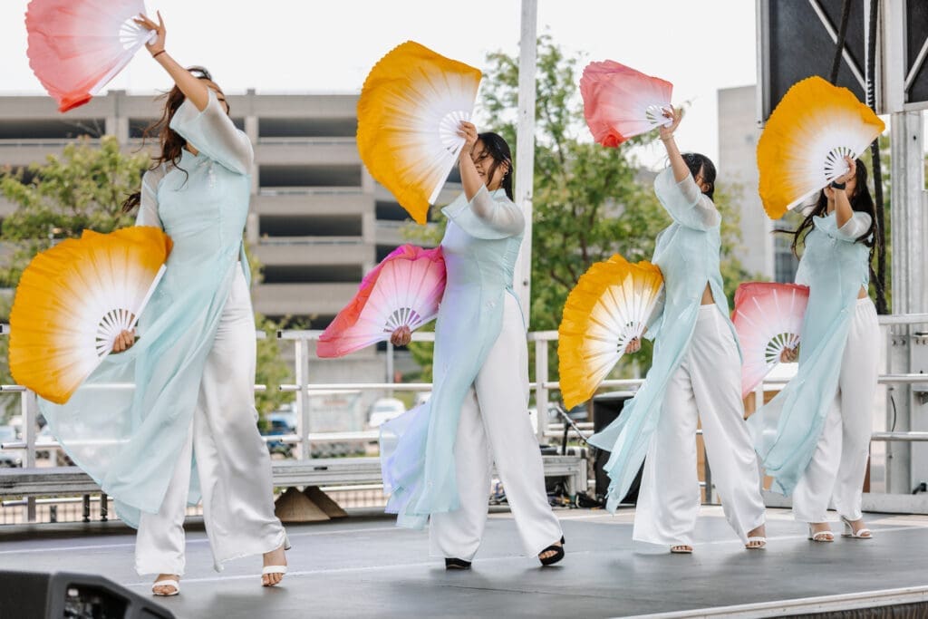 Cultural dancers perform in traditional costumery and fans on stage at Panda Fest in Phoenix