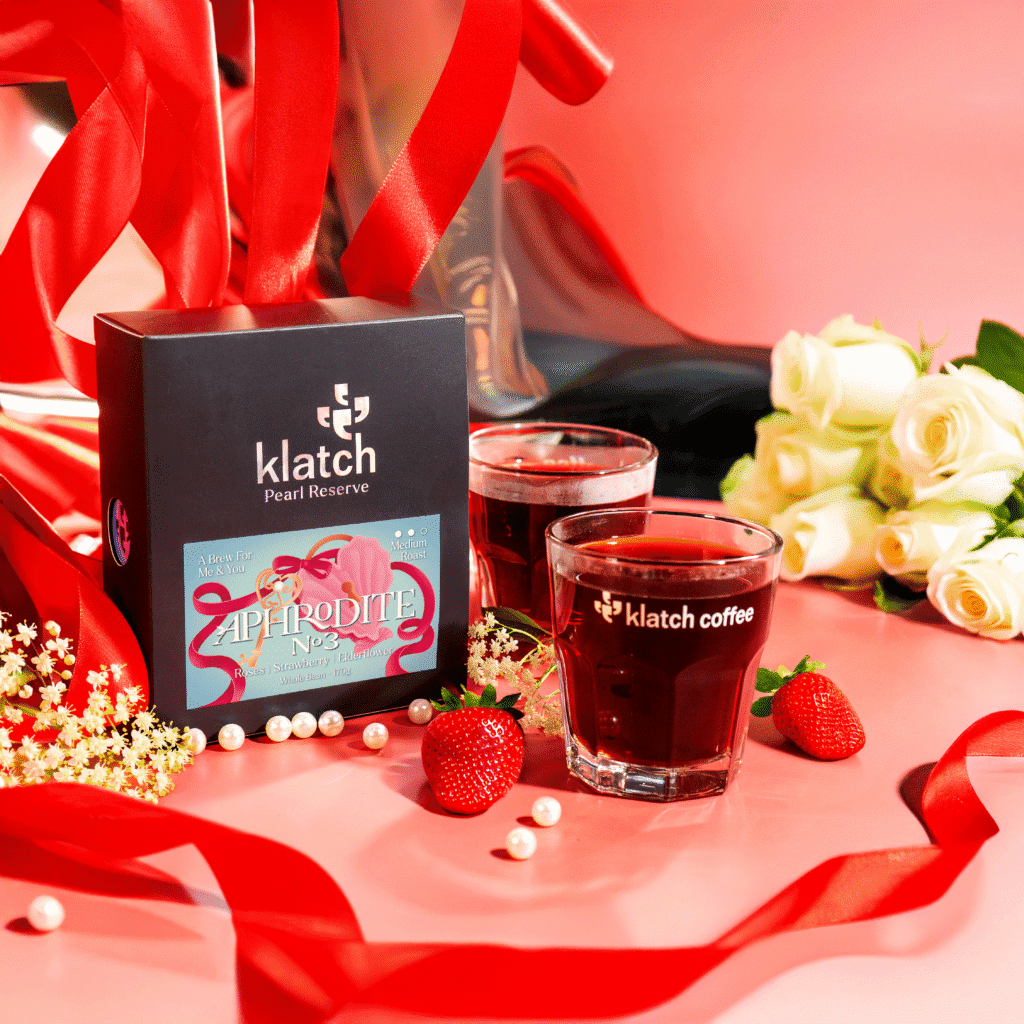 Klatch Coffee Aphrodite No. 3 limited-edition Valentine’s coffee displayed with brewed cups, strawberries, pearls, and red ribbon accents.
