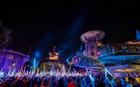 Disneyland After Dark Star Wars Nite with crowds waving illuminated lightsabers in Galaxy’s Edge after hours.