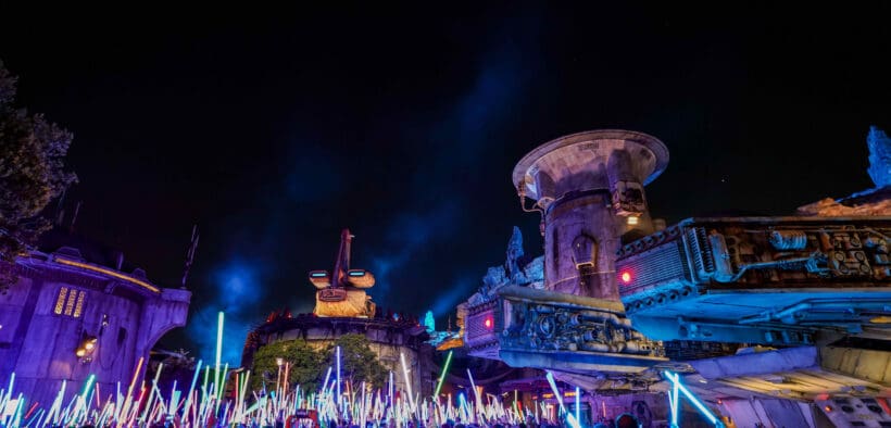 Disneyland After Dark Star Wars Nite with crowds waving illuminated lightsabers in Galaxy’s Edge after hours.