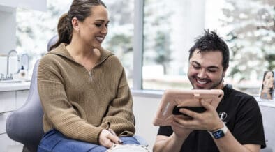 Provider reviewing treatment plan on an iPad with a patient inside Facial Aesthetics’ Westminster medical spa.
