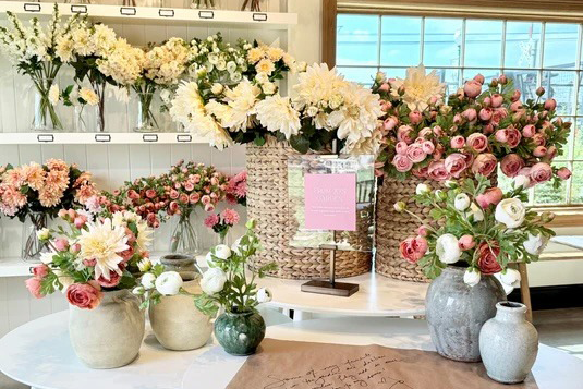 Interior of The Flower Shoppe in Waco featuring large floral arrangements and woven baskets filled with blooms.