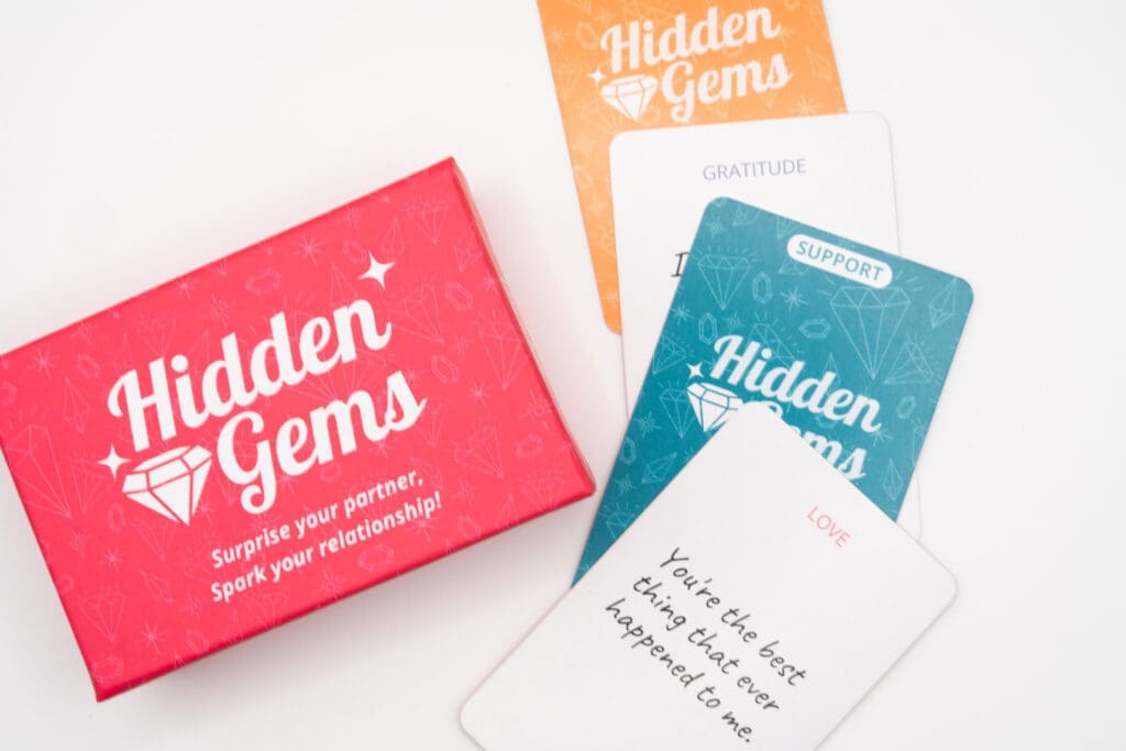 Hidden Gems relationship card deck with colorful prompt cards focused on love, gratitude, support, and connection, designed to be hidden and discovered by partners in everyday moments.