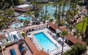 Aerial view of Murrieta Hot Springs Resort in California featuring geothermal soaking pools, palm-lined grounds and central hydrotherapy areas.
