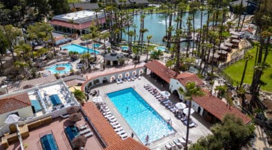 Aerial view of Murrieta Hot Springs Resort in California featuring geothermal soaking pools, palm-lined grounds and central hydrotherapy areas.
