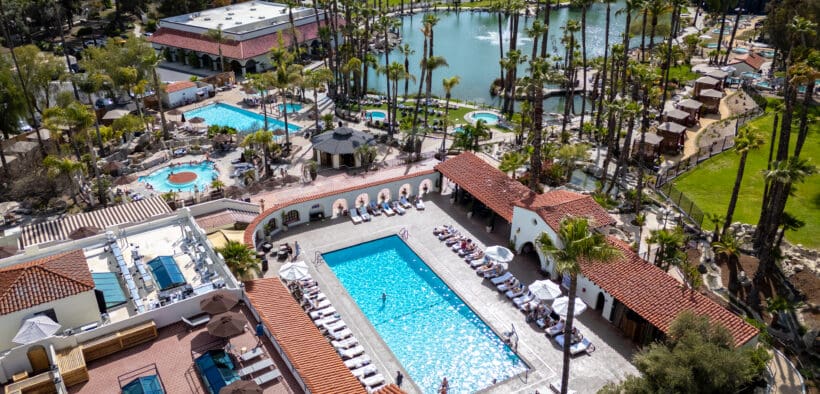Aerial view of Murrieta Hot Springs Resort in California featuring geothermal soaking pools, palm-lined grounds and central hydrotherapy areas.