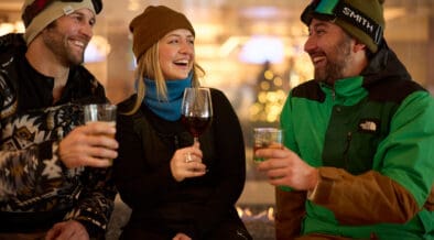 Guests in ski gear enjoy après drinks together at Hotel Alpenrock in Breckenridge, celebrating winter dining and social moments indoors.