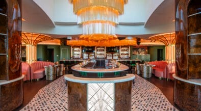 JING Scottsdale entry featuring a large gold chandelier, circular bar seating and art deco-inspired columns.