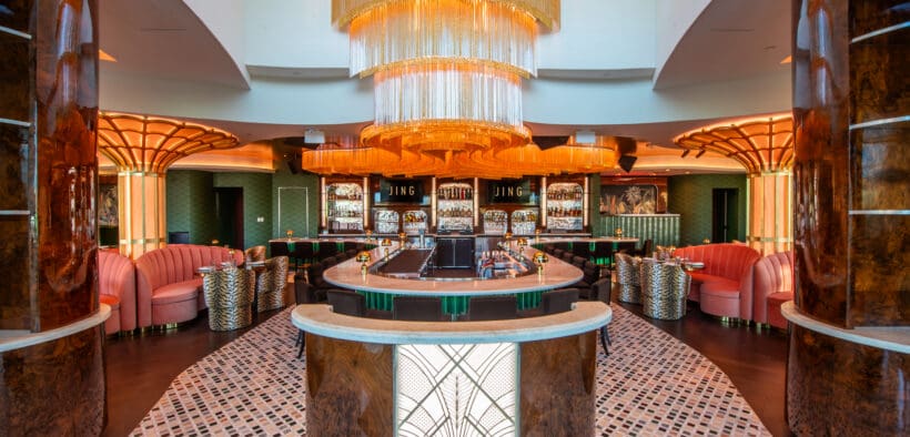 JING Scottsdale entry featuring a large gold chandelier, circular bar seating and art deco-inspired columns.