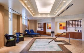 Indoor spa whirlpool at JW Marriott Desert Springs Resort & Spa with bubbling water, lounge chairs and warm neutral tile design in Palm Desert.