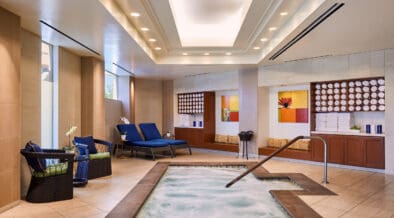 Indoor spa whirlpool at JW Marriott Desert Springs Resort & Spa with bubbling water, lounge chairs and warm neutral tile design in Palm Desert.