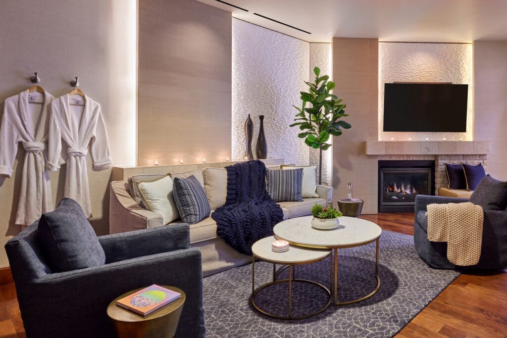 Luxurious spa suite lounge at JW Marriott Desert Springs Resort & Spa with plush seating, fireplace, textured walls and refreshments in Palm Desert.