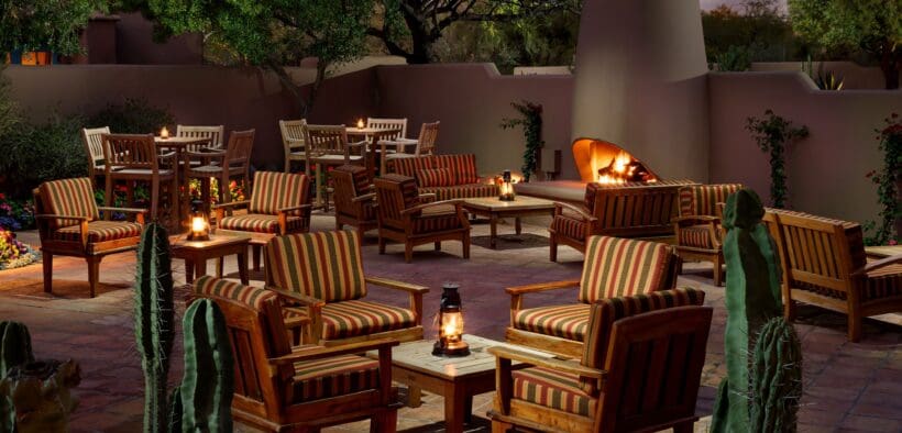 Exterior view of The Hermosa Inn with blooming bougainvillea, garden pathways, and Camelback Mountain in the background.
