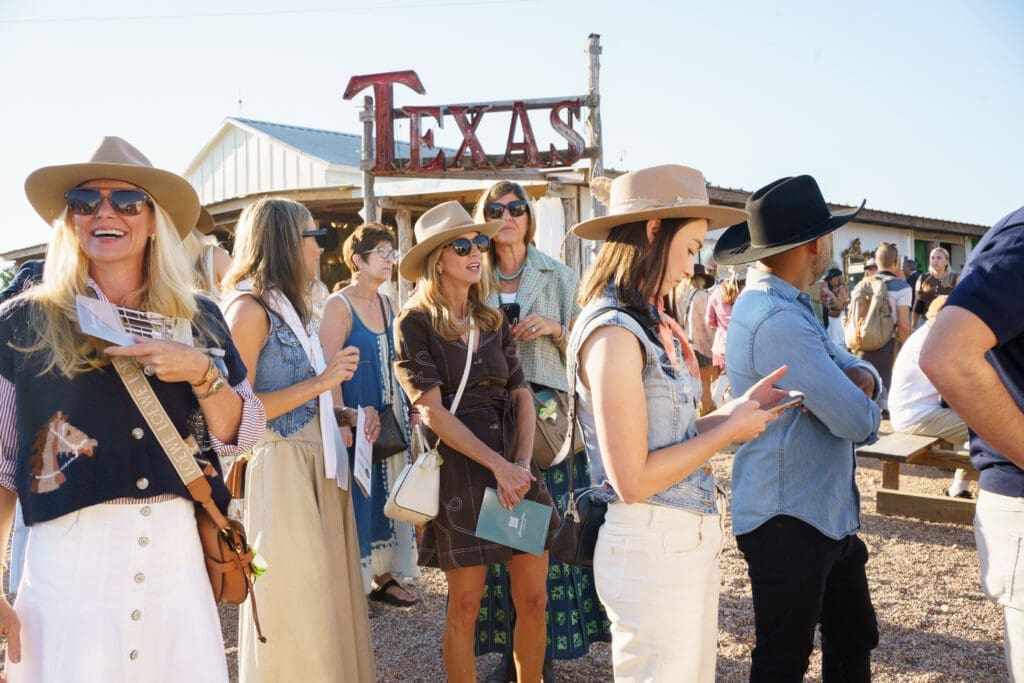 Attendees gathered at the Marburger Farm Antique Show Spring Show in Round Top, Texas, with the Texas sign visible in the background.