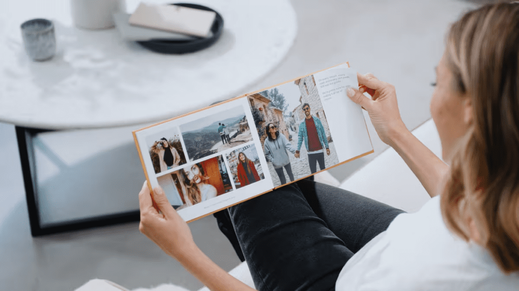 Person flipping through a personalized photo book filled with travel and couple memories, showcasing a curated layout of meaningful photos designed as a sentimental keepsake gift.