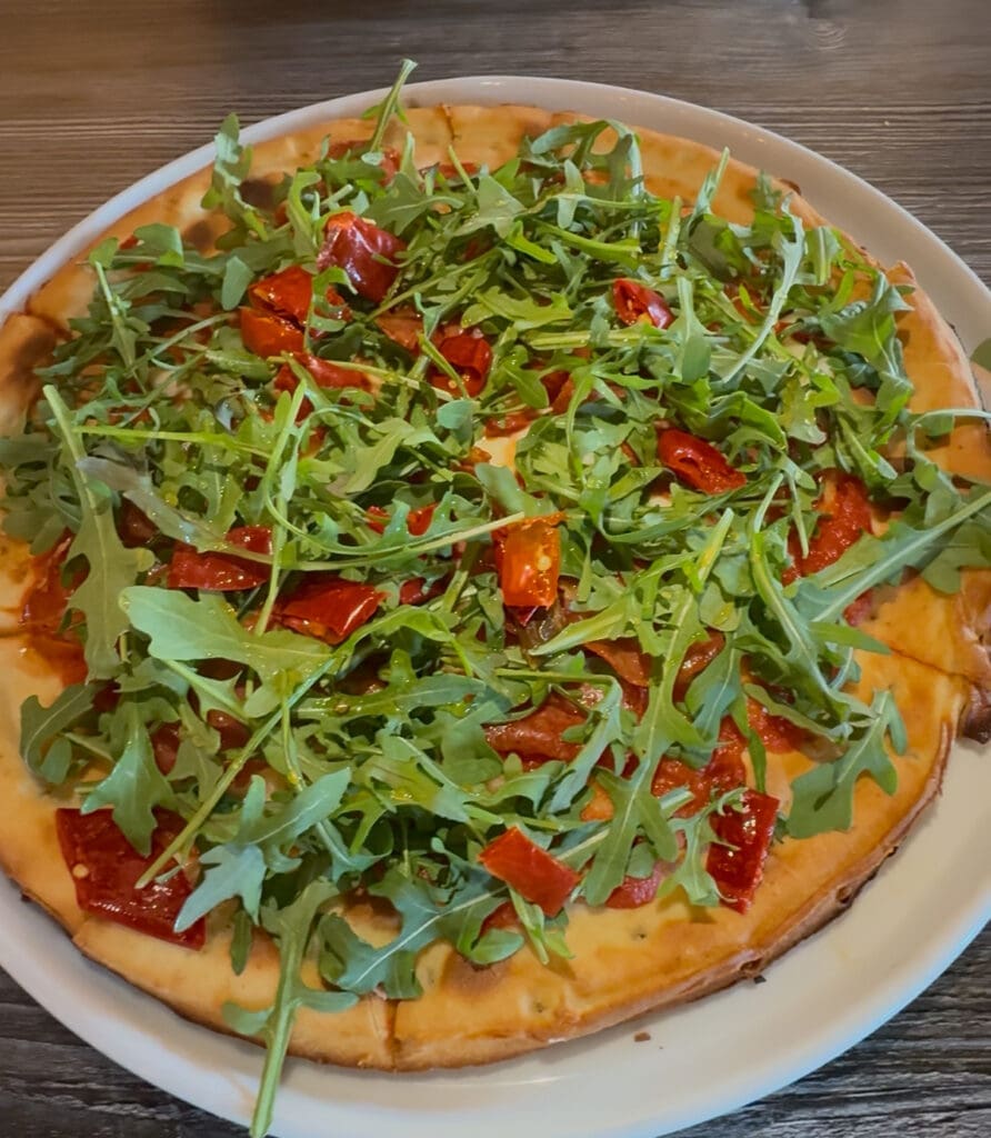 The Calabrian pizza at Patricia’s Pizza topped with arugula, Calabrese salami and spicy giardiniera on a gluten-free crust.