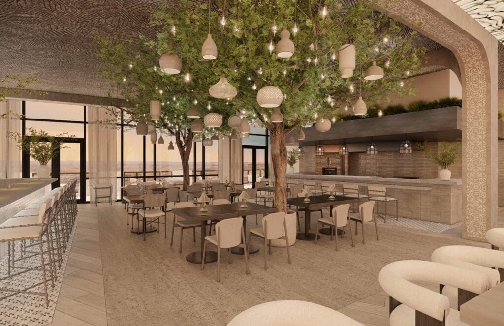Interior dining space at Aleteo at The Monarch San Antonio, featuring tree-inspired design, suspended lighting and floor-to-ceiling windows overlooking downtown.