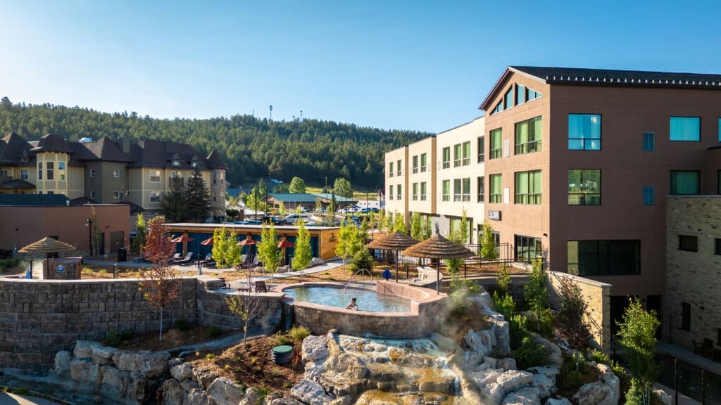 Geothermal soaking pool at The Springs Resort in Pagosa Springs overlooking the San Juan River with mountain views and rising steam. 