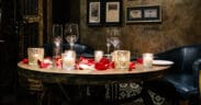 Romantic Valentine’s Day dinner setting with candles and rose petals at T. Cook's restaurant at Royal Palms Resort and Spa.