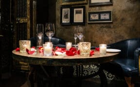 Romantic Valentine’s Day dinner setting with candles and rose petals at T. Cook's restaurant at Royal Palms Resort and Spa.