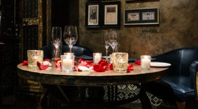 Romantic Valentine’s Day dinner setting with candles and rose petals at T. Cook's restaurant at Royal Palms Resort and Spa.