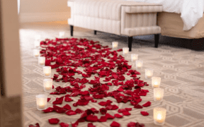 Rose petals and candlelight arranged on the floor of a luxury hotel suite at The Venetian Resort Las Vegas for a romantic Valentine’s Day setup.