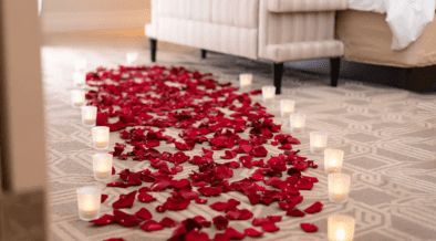 Rose petals and candlelight arranged on the floor of a luxury hotel suite at The Venetian Resort Las Vegas for a romantic Valentine’s Day setup.