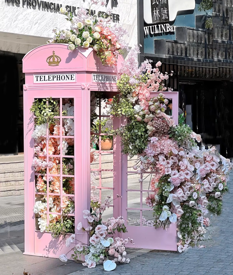 Pink floral-covered phone booth photo installation at Desert Ridge Marketplace in Phoenix, Arizona, created for a Valentine’s Day event with live music and romantic ambiance.