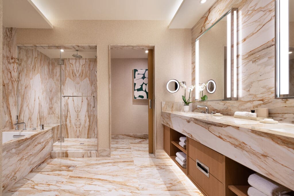 Grand Suite bathroom at Green Valley Ranch featuring marble walls, soaking tub, glass shower and double vanity.