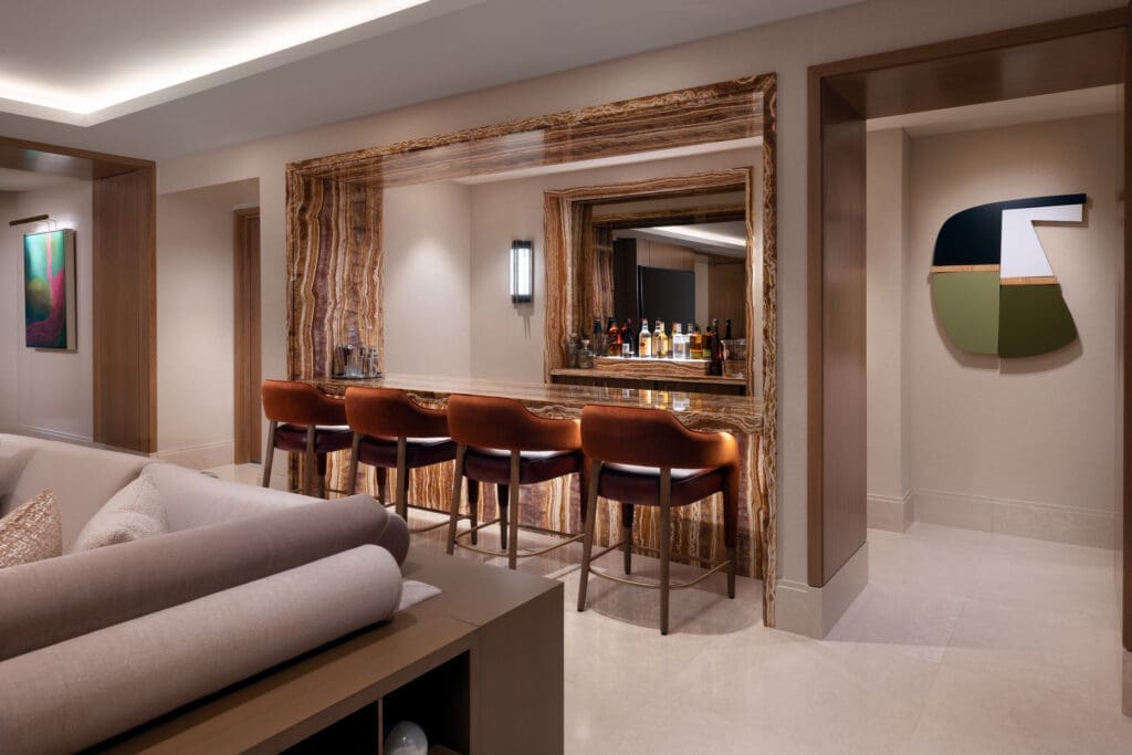 Luxury suite bar at Green Valley Ranch featuring red tiger onyx stone bar and leather bar stools.