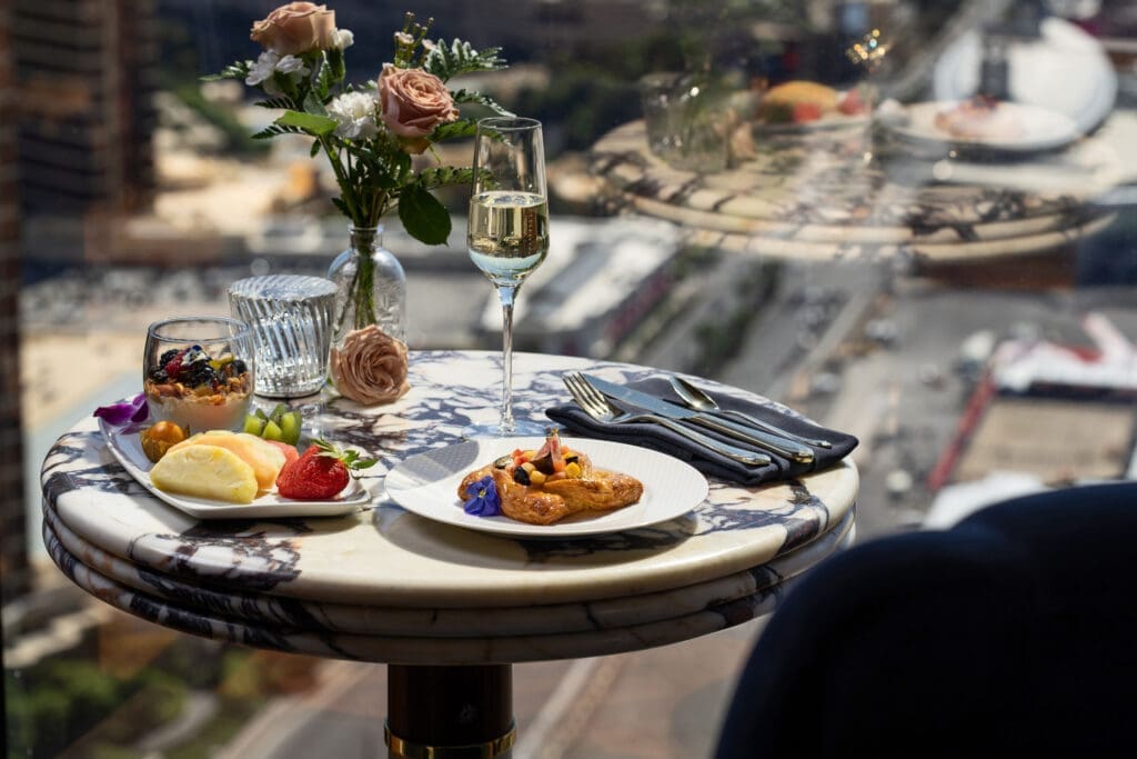 Dining experience at Club 66 at Resorts World Las Vegas featuring champagne, pastries and Las Vegas Strip views from the Conrad tower.