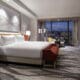 Luxury guest room at Conrad Las Vegas at Resorts World featuring floor-to-ceiling views of the Las Vegas Strip and modern interior design.