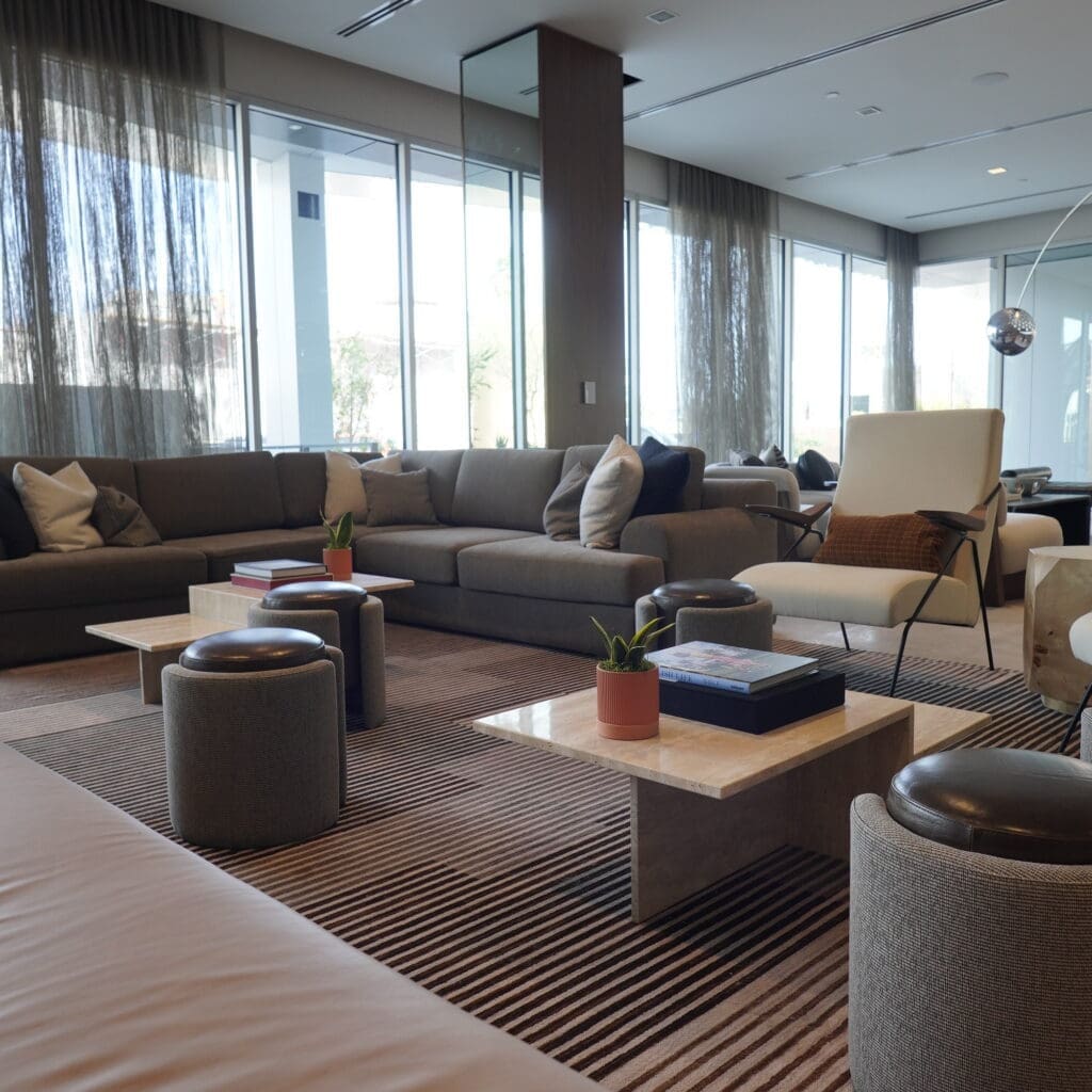 Modern lobby lounge at AC Hotel Scottsdale Old Town with neutral sofas, layered textures and floor-to-ceiling windows.