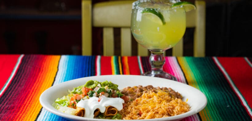 Mexican plate with rolled tacos, rice, beans, guacamole and margarita at Frank & Lupe’s in Scottsdale Arizona.