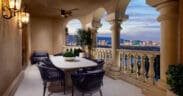 Outdoor terrace at Green Valley Ranch with dining table, arched columns and views of the Las Vegas Strip at dusk.