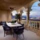 Outdoor terrace at Green Valley Ranch with dining table, arched columns and views of the Las Vegas Strip at dusk.