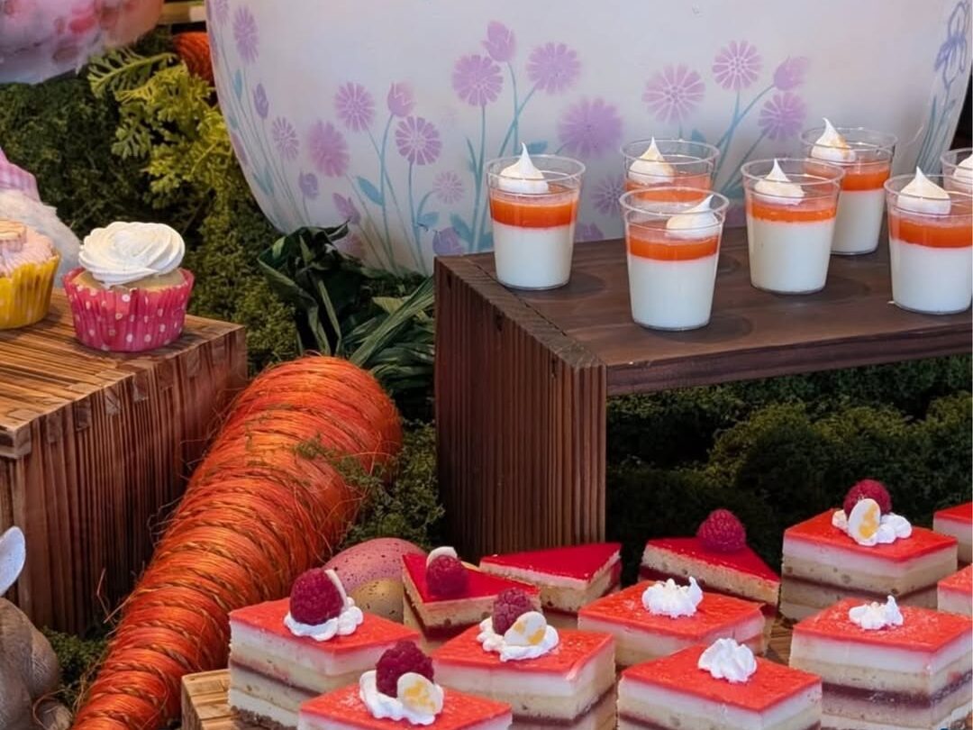 Easter dessert display featuring layered cakes, mini parfaits and cupcakes with carrot-themed decor at La Luz Restaurant brunch in Tucson, Arizona.