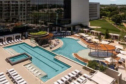 Loews Arlington Hotel, Facebook pool complex with lounge chairs, cabanas and a large hotel building overlooking the water.