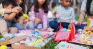 Family and friends are painting colorful easter eggs during an outdoor celebration in New Mexico.