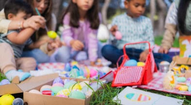 Family and friends are painting colorful easter eggs during an outdoor celebration in New Mexico.