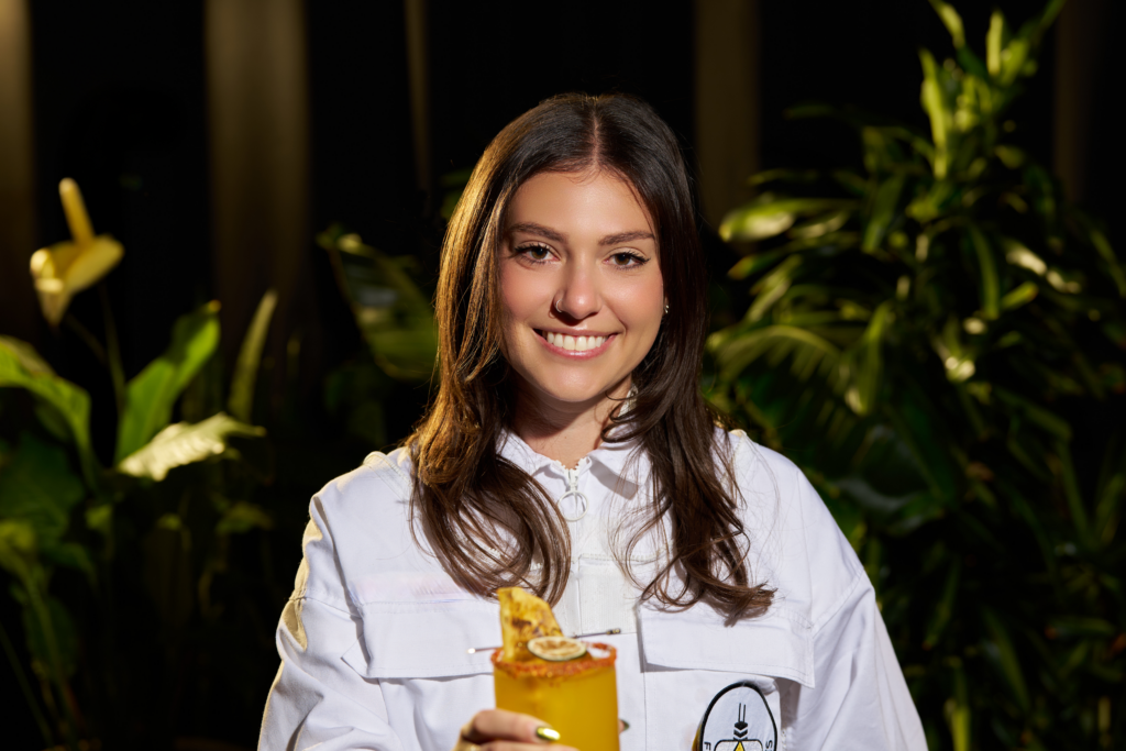 Isabella Sandoval holding a cocktail during the Viva Abejas campaign celebrating pollinators and sustainable food systems.