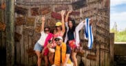 Group of friends posing for a photo in front of a rustic wooden sign display on South Padre Island.