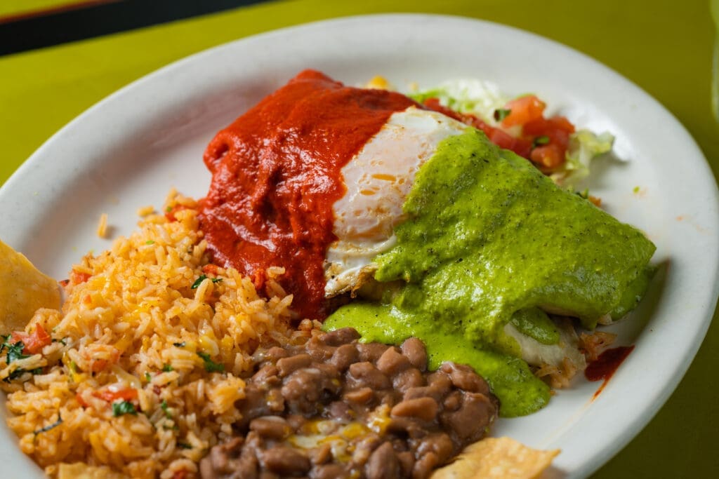Close-up of enchiladas with red and green chile sauce, rice and beans at Frank & Lupe’s Scottsdale Mexican restaurant.