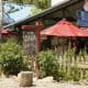 Colorful coffee shop patio with red umbrellas and rustic signage in Madrid, New Mexico.