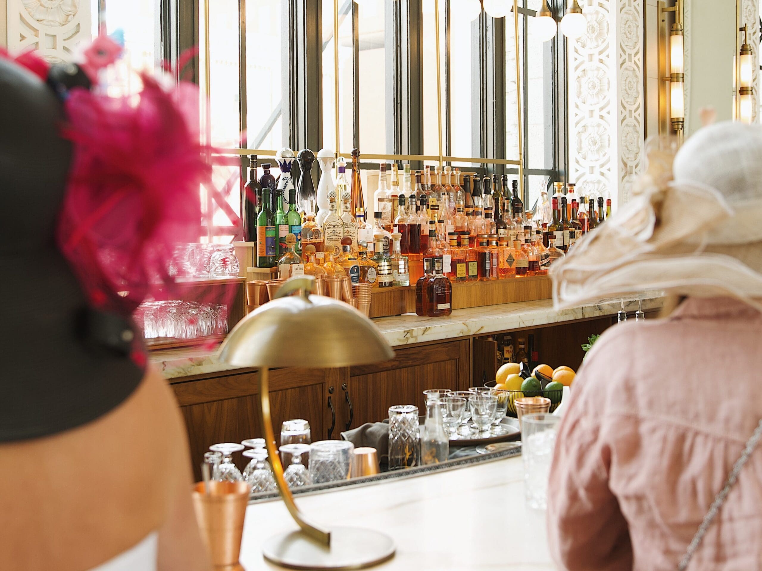 Interior of The Cooper Lounge at Denver Union Station with bar seating, cocktails and guests in Derby hats creating an upscale event atmosphere.