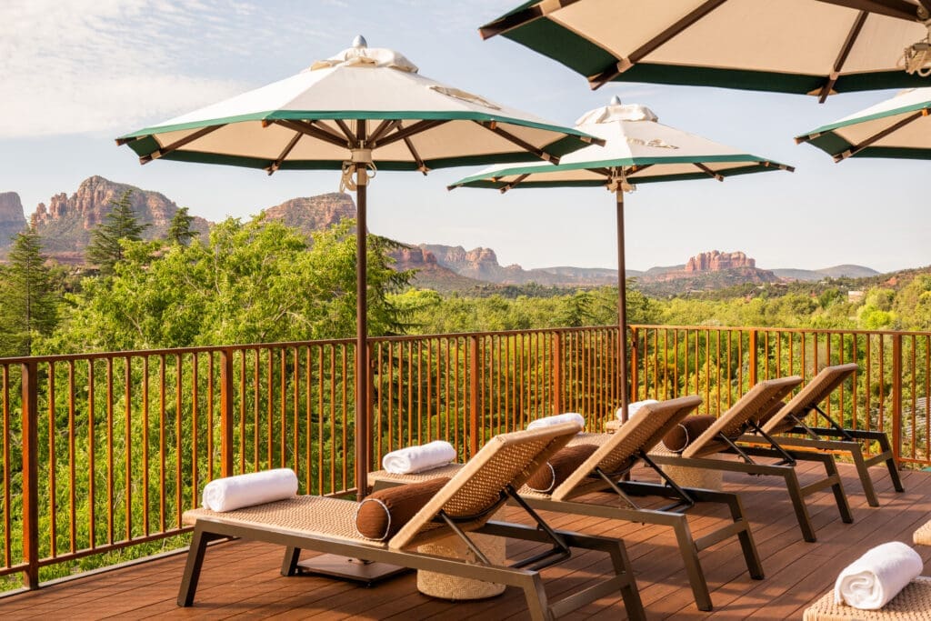 Pool deck with lounge chairs and private cabanas at L’Auberge de Sedona luxury resort in Sedona Arizona.