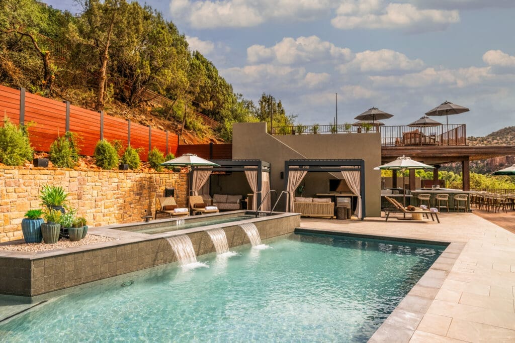 Luxury pool with cabanas and waterfall features at L’Auberge de Sedona resort in Sedona Arizona.