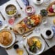 A spread of brunch foods: pancakes eggs, coffee, charcuterie boards on a talbe at Greenfinch, Estancia La Jolla Hotel & Spa.