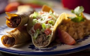 Flautas and ground beef tacos served with rice and garnish at El Paso Mexican restaurant.